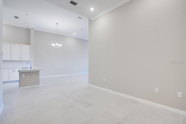 unfurnished living room with crown molding, sink, light tile patterned flooring, and an inviting chandelier