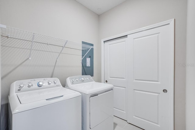 clothes washing area featuring separate washer and dryer and light tile patterned floors