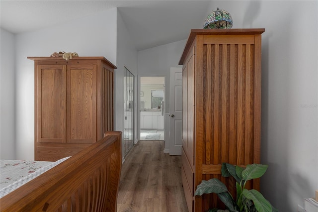 hallway featuring dark hardwood / wood-style flooring and lofted ceiling