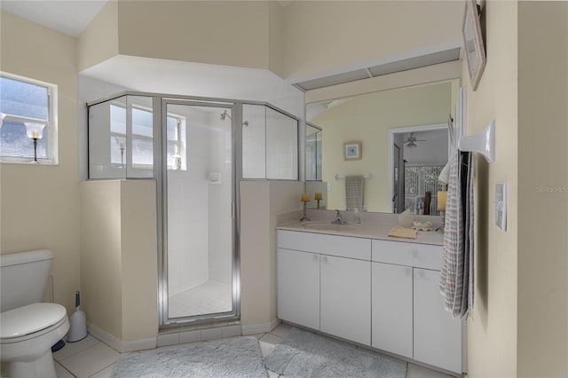 bathroom featuring ceiling fan, tile patterned floors, toilet, vanity, and a shower with shower door