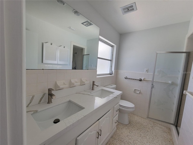 bathroom with tile walls, walk in shower, and vanity