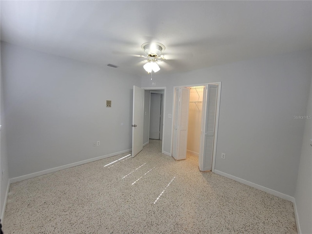 unfurnished bedroom with ceiling fan and a closet