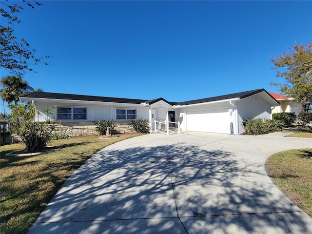 ranch-style home featuring a front lawn and a garage