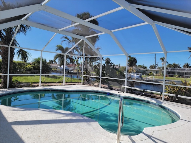 view of pool featuring a patio area, a lanai, and a water view