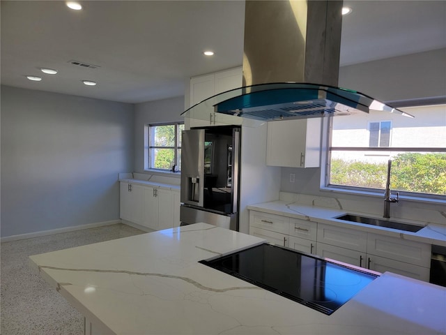 kitchen featuring white cabinetry, island range hood, sink, light stone counters, and black cooktop