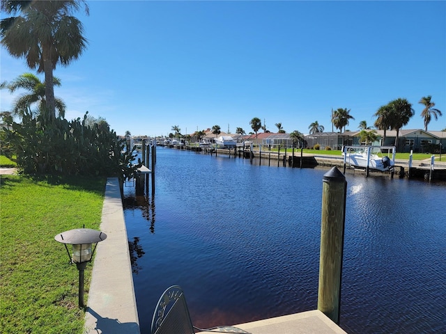 view of dock featuring a lawn and a water view