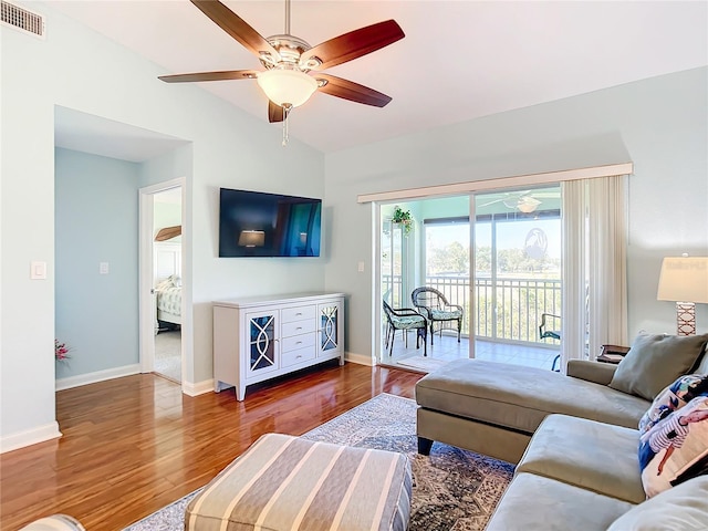 living room with hardwood / wood-style floors, ceiling fan, and lofted ceiling