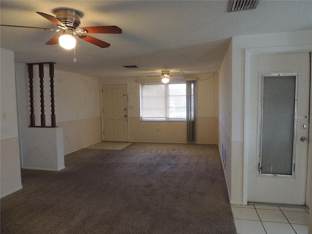 carpeted empty room with ceiling fan and a textured ceiling