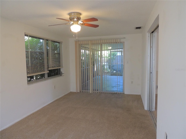 carpeted empty room featuring ceiling fan