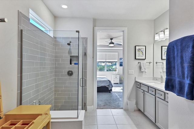 bathroom featuring a shower with shower door, vanity, ceiling fan, and tile patterned flooring