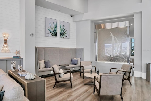 sitting room with a towering ceiling and light hardwood / wood-style floors