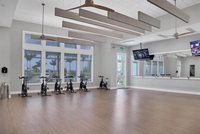 workout area featuring hardwood / wood-style floors, a towering ceiling, and ceiling fan