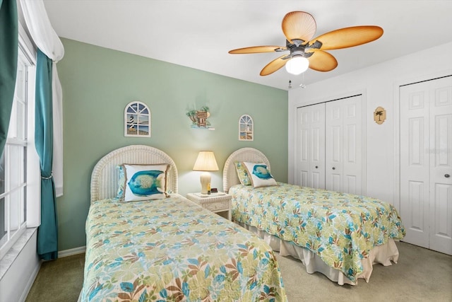 bedroom featuring a ceiling fan, carpet flooring, baseboards, and two closets