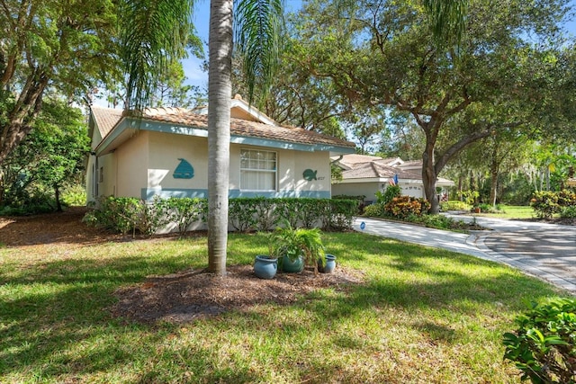 view of side of home featuring a lawn and stucco siding