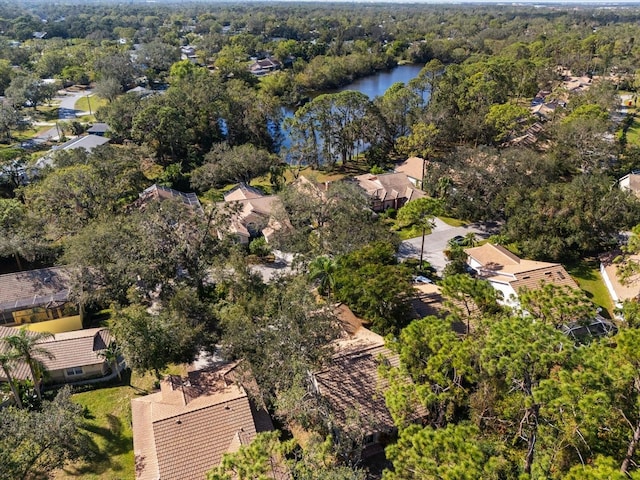 bird's eye view with a water view and a wooded view