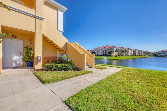 view of property's community with a yard and a water view