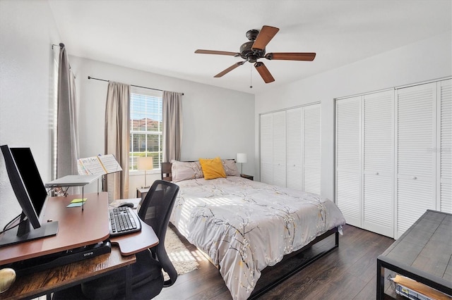 bedroom with ceiling fan, dark wood-type flooring, and multiple closets