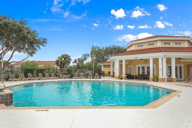 view of swimming pool featuring french doors, ceiling fan, and a patio area