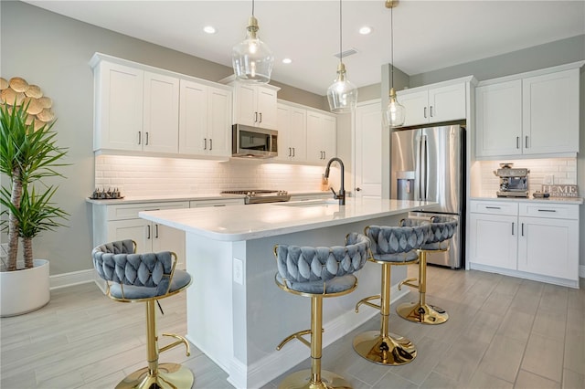 kitchen with white cabinets, a kitchen bar, and stainless steel appliances