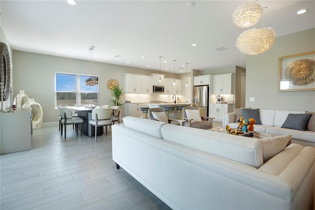 living room with light hardwood / wood-style flooring and a chandelier