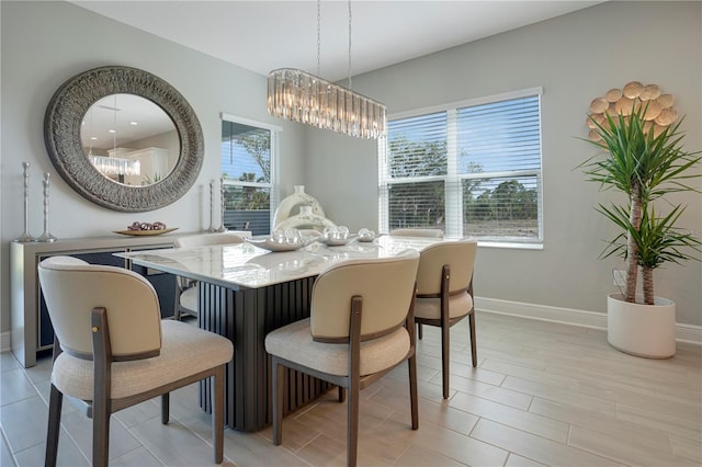 dining space with a healthy amount of sunlight, light hardwood / wood-style flooring, and an inviting chandelier