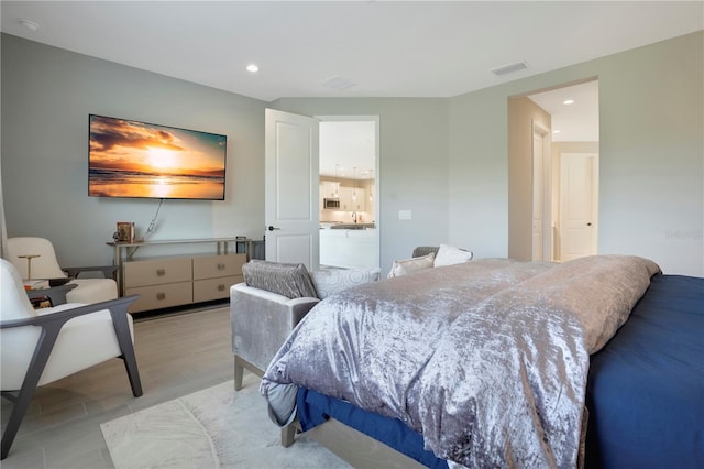 bedroom featuring light hardwood / wood-style floors and sink