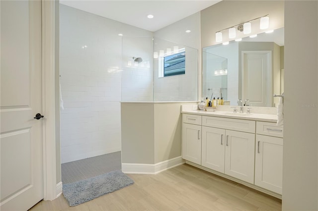 bathroom with a tile shower, hardwood / wood-style floors, and vanity