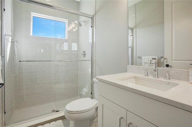 bathroom with wood-type flooring, vanity, a shower with shower door, and toilet