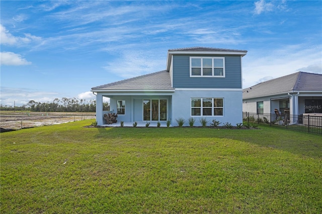 rear view of house featuring a lawn