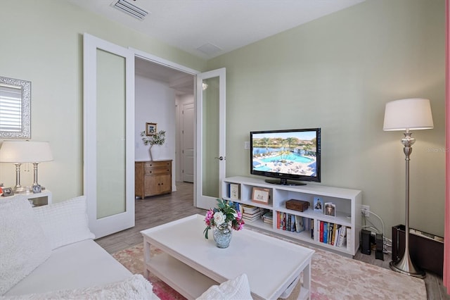 living room with light hardwood / wood-style flooring and french doors