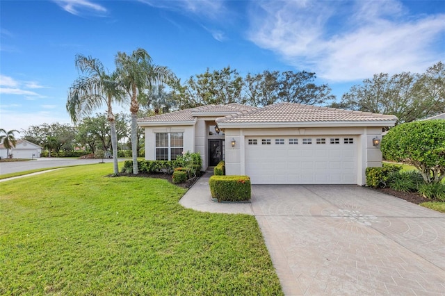 mediterranean / spanish-style house featuring a front yard and a garage