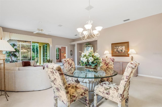 carpeted dining room featuring ceiling fan with notable chandelier