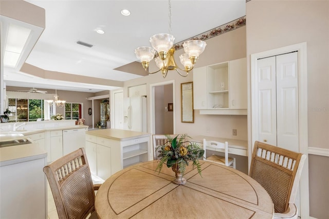 dining area featuring ceiling fan with notable chandelier