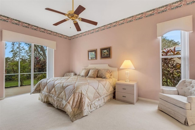 carpeted bedroom with multiple windows and ceiling fan