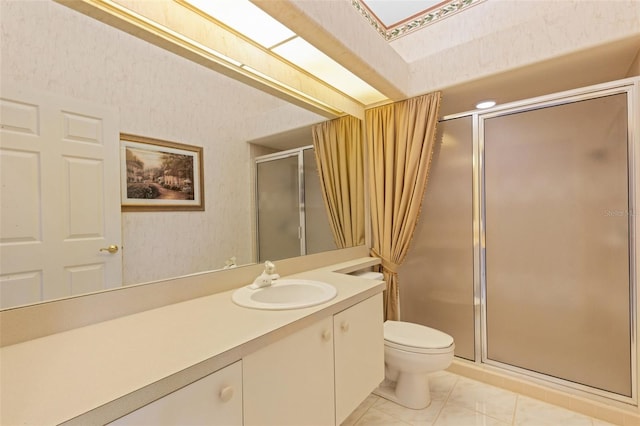 bathroom with vanity, toilet, and a shower with door