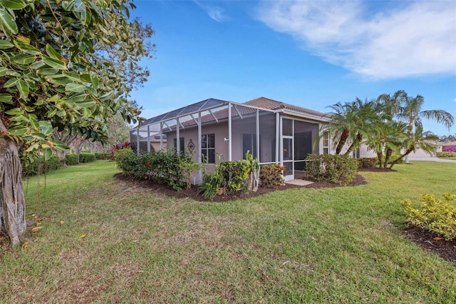 back of property featuring a lawn and a lanai