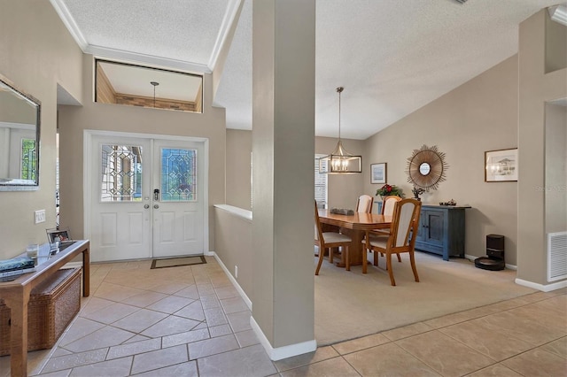 entrance foyer featuring lofted ceiling, light carpet, french doors, an inviting chandelier, and a textured ceiling