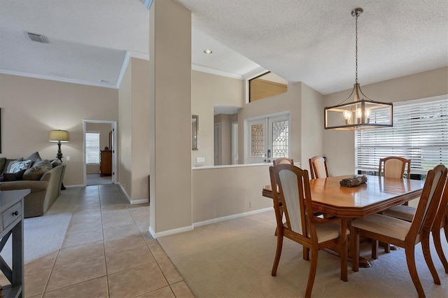 dining space featuring light tile patterned floors, a chandelier, a textured ceiling, and ornamental molding