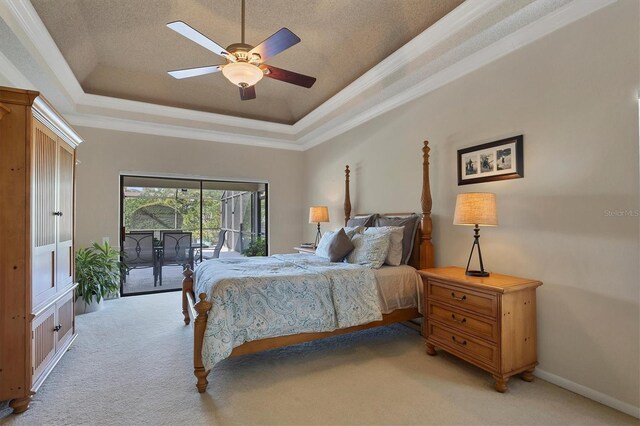 bedroom featuring light carpet, access to exterior, a tray ceiling, and ceiling fan