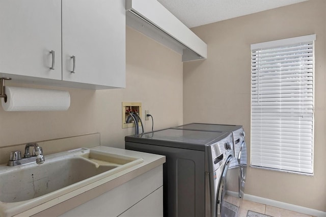 laundry area featuring cabinets, sink, independent washer and dryer, a textured ceiling, and light tile patterned floors