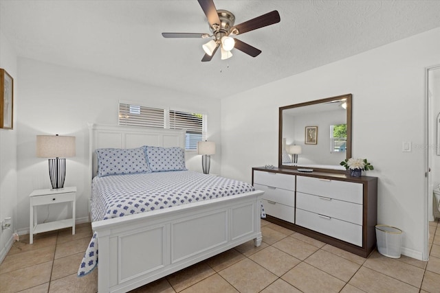 tiled bedroom with ceiling fan and a textured ceiling