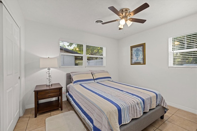 tiled bedroom featuring a closet and ceiling fan