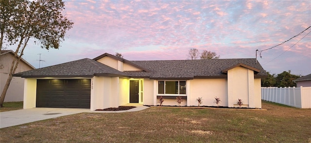 ranch-style house with a garage and a yard