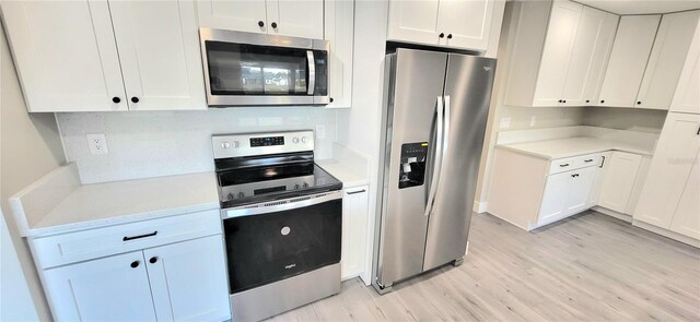 kitchen featuring white cabinetry, light countertops, light wood-type flooring, and stainless steel appliances