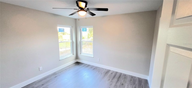 empty room with baseboards, ceiling fan, and light wood finished floors