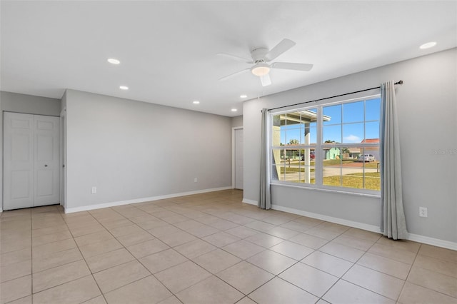 tiled spare room featuring ceiling fan