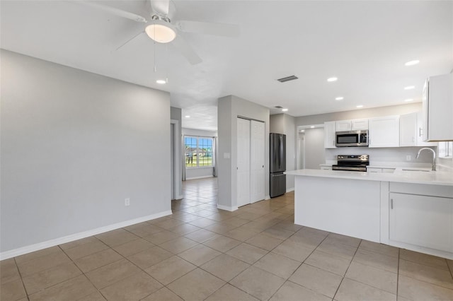 kitchen featuring white cabinets, sink, ceiling fan, appliances with stainless steel finishes, and kitchen peninsula