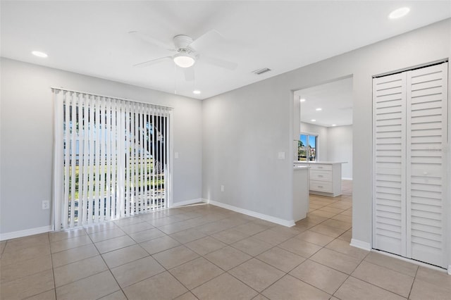 tiled empty room featuring ceiling fan