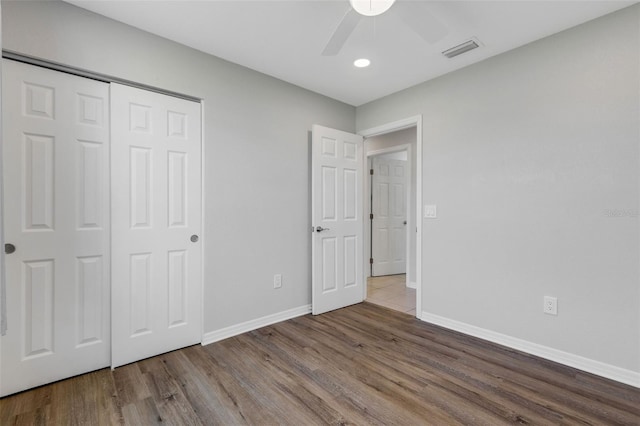 unfurnished bedroom featuring hardwood / wood-style flooring, ceiling fan, and a closet