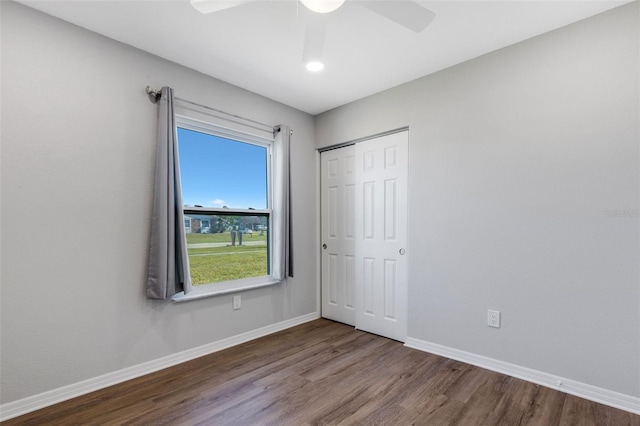 unfurnished bedroom featuring hardwood / wood-style floors, ceiling fan, and a closet